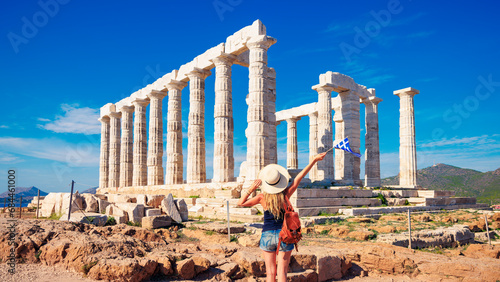Young female tourist enjoying ancient temple of Poseidon, Cape Sounion near Athens in Greece photo