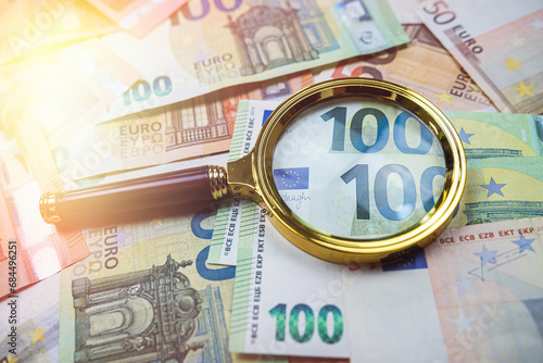  magnifying glass above euro banknote as finance background