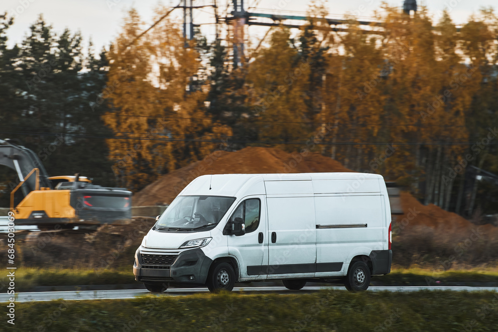 A white van on the road, shipping cargo and packages from the warehouse to the customers, showing the design and branding of their logistics service.