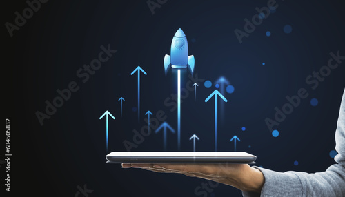 Digital rocket launching from tablet on hand. Online startup and progress concept