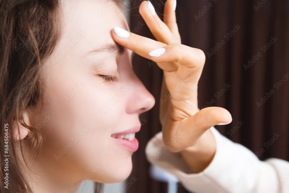 makeup artist applies bronzer to a client's face in a beauty salon. Hand of cosmetologist applying mask with finger on woman makeup artist applies bronzer to a client's face in a beauty salon. Hand of cosmetologist applying mask with finger on woman