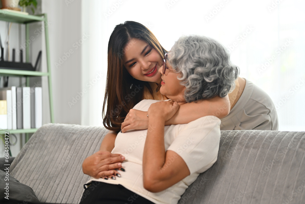 Loving daughter hugging middle aged mother from back. Family bonding concept Loving daughter hugging middle aged mother from back. Family bonding concept