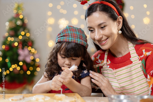 Happy family christmas day. Parents and daughter celebrate Christmas happily in their own home. Little girl enjoying make cookie bakery desserts on food table holiday merry festive activities.
