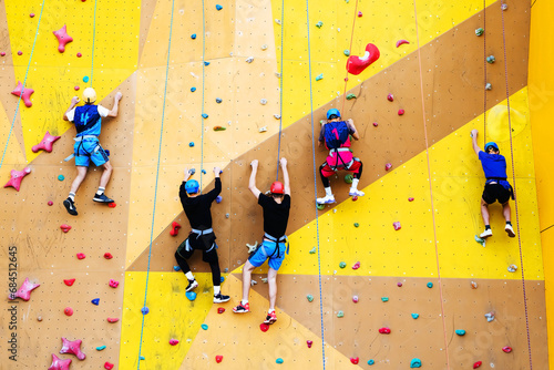 Wallpaper Mural A group of climbers athletes compete in a high-speed ascent of a steep wall. Sports events at the climbing wall. Unrecognizable person Torontodigital.ca