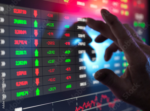 Hand of trader examining investment performance data on screen photo