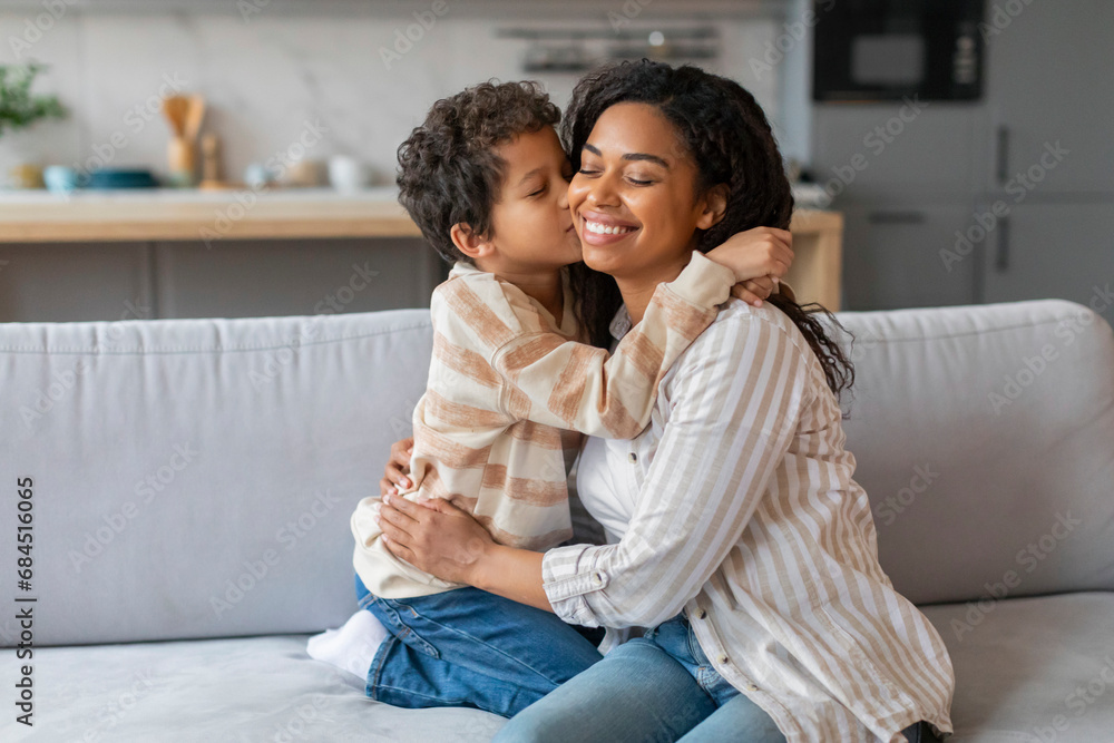 Preteen Black Boy Kissing His Happy Mother While They Bonding At Home Preteen Black Boy Kissing His Happy Mother While They Bonding At Home