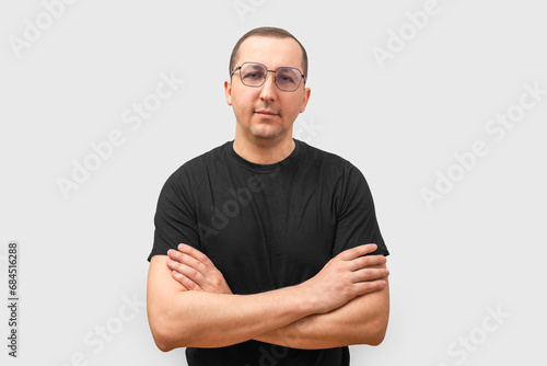 Portrait of a young man looking at the camera on a light background.