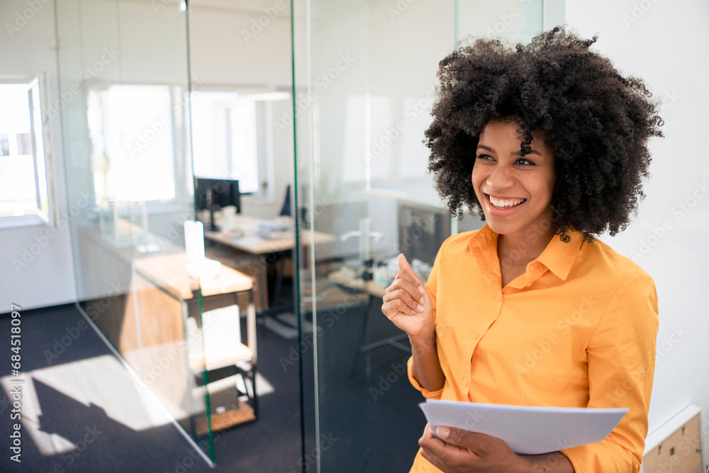 Excited businesswoman holding document at office Excited businesswoman holding document at office