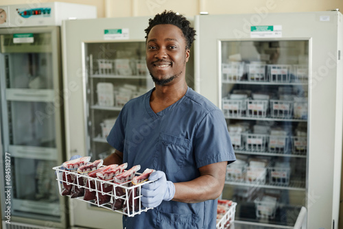 Smiling lab technician holding blood bags photo