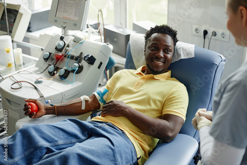 Smiling donor talking with healthcare worker at blood donation center photo