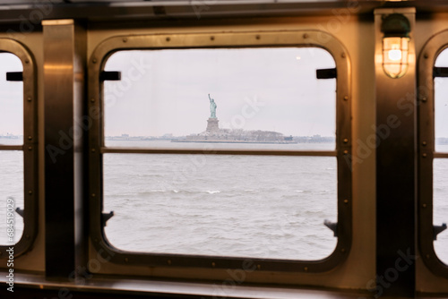 Statue of Liberty seen through window of Staten Island Ferry in Hudson River photo