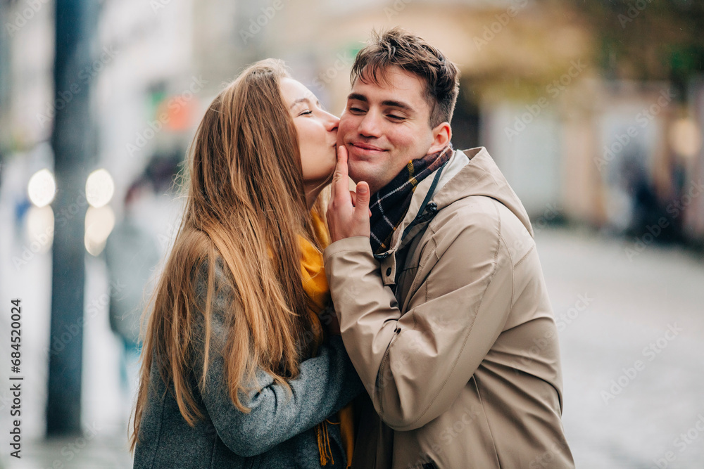 Girlfriend kissing on boyfriend's cheek at street Girlfriend kissing on boyfriend's cheek at street