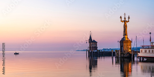 Germany, Baden-Wurttemberg, Konstanz, Harbor on shore of Bodensee at dawn with Imperia statue in foreground photo