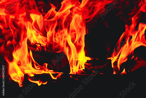 Burning log of firewood in fireplace. Texture of a blazing fire in the fireplace Close up abstract background