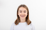 Brunette girl smiling with braces on her teeth on a white background isolated.