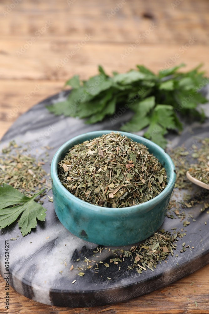 Dried parsley in bowl on wooden table, closeup. Space for text Dried parsley in bowl on wooden table, closeup. Space for text