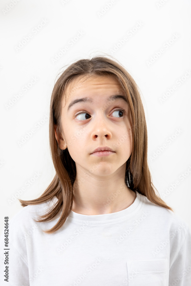 Little girl looks to the side in surprise on a white background isolated. Little girl looks to the side in surprise on a white background isolated.