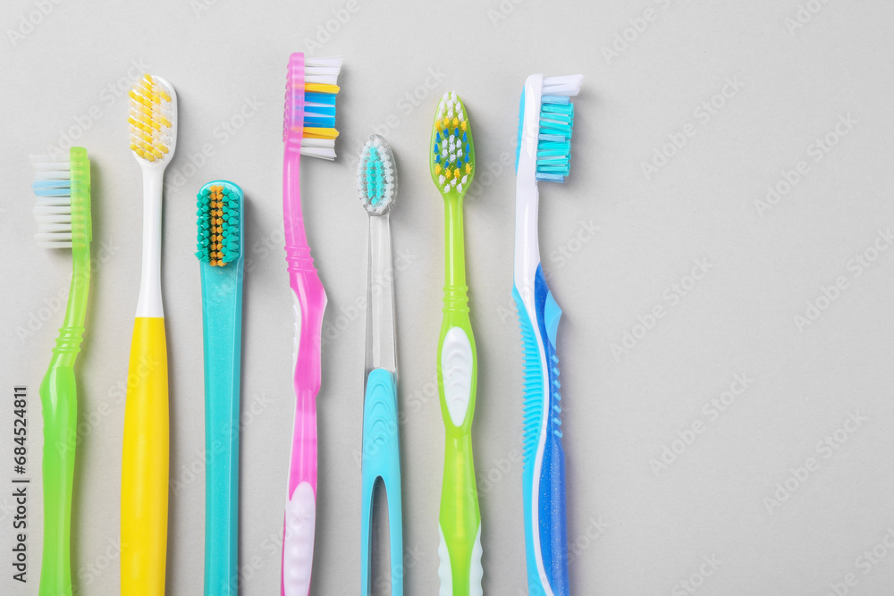 Many different toothbrushes on light background, flat lay. Space for text Many different toothbrushes on light background, flat lay. Space for text