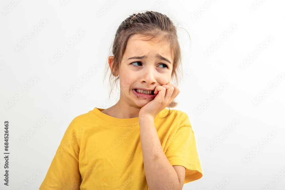 Scared and anxious girl, biting her fingernails on a white background isolated. Scared and anxious girl, biting her fingernails on a white background isolated.