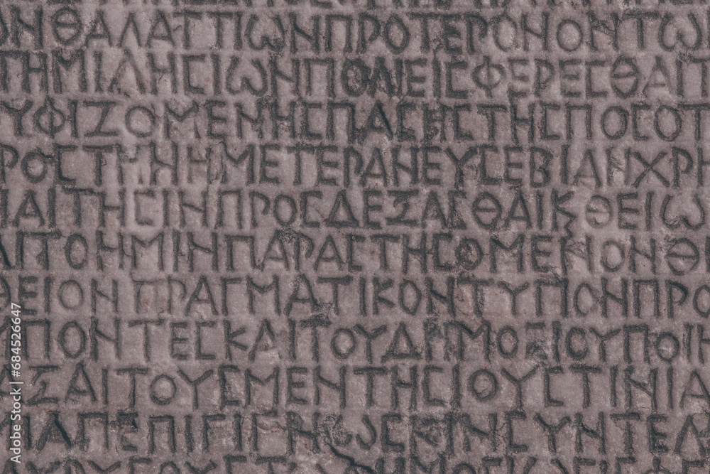 Retro text background. Fragment of ancient inscription (imperial law in ancient Greek language), carved on marble block. Monochrome. Ancient Miletus, Turkey (Turkiye). Ancient art and history concept Retro text background. Fragment of ancient inscription (imperial law in ancient Greek language), carved on marble block. Monochrome. Ancient Miletus, Turkey (Turkiye). Ancient art and history concept
