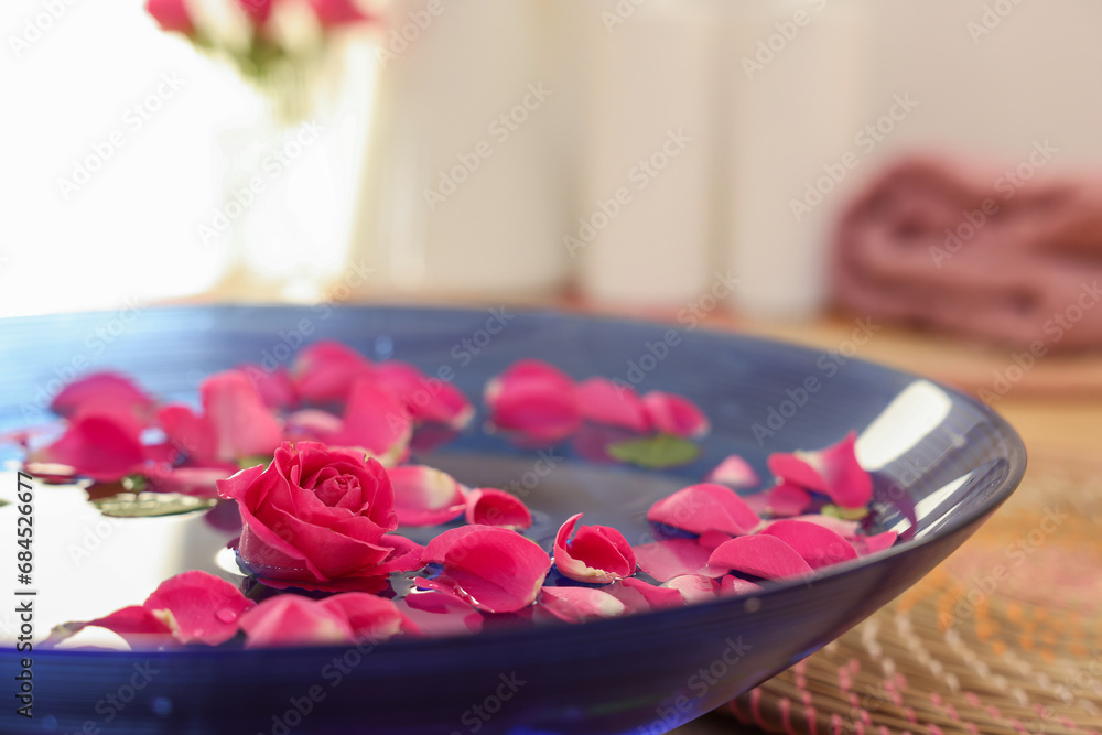Pink roses and petals in bowl with water on table, closeup Pink roses and petals in bowl with water on table, closeup