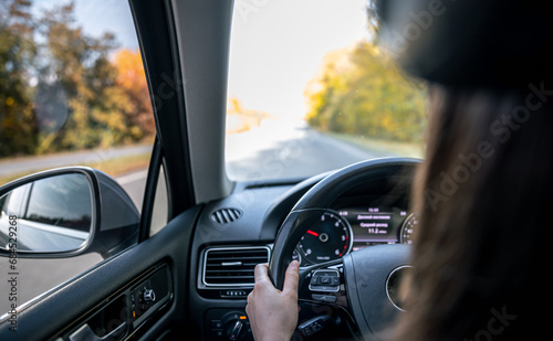 Woman driver's hands on the steering wheel inside the car.