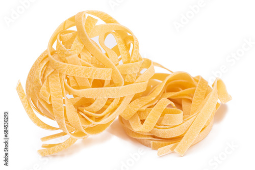 Two Classic Italian Raw Egg Fettuccine - Isolated on White Background. Dry Twisted Uncooked Pasta. Italian Culture and Cuisine. Raw Golden Macaroni Pattern - Isolation