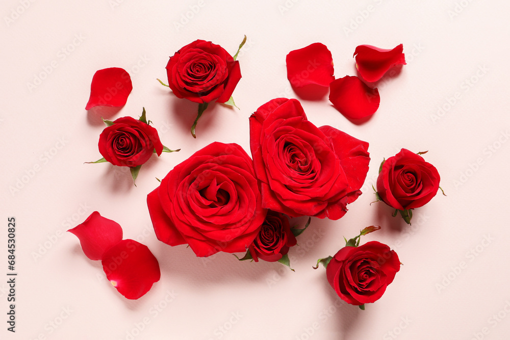 Beautiful red roses and petals on pale pink background, flat lay Beautiful red roses and petals on pale pink background, flat lay