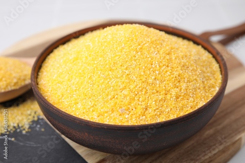 Raw cornmeal in bowl on table, closeup