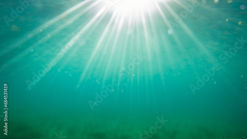Underwater view of the sea surface with sunbeams and lens flare