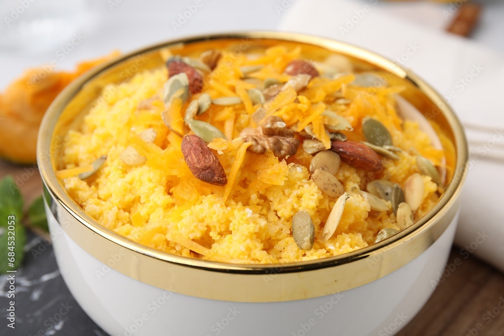 Tasty cornmeal with nuts, pumpkin and seeds in bowl on table, closeup Tasty cornmeal with nuts, pumpkin and seeds in bowl on table, closeup