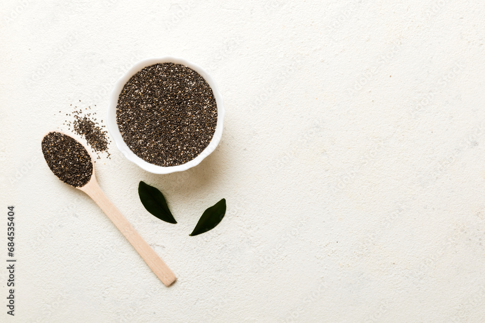 Chia seeds in bowl and spoon on colored background. Healthy Salvia hispanica in small bowl. Healthy superfood Chia seeds in bowl and spoon on colored background. Healthy Salvia hispanica in small bowl. Healthy superfood