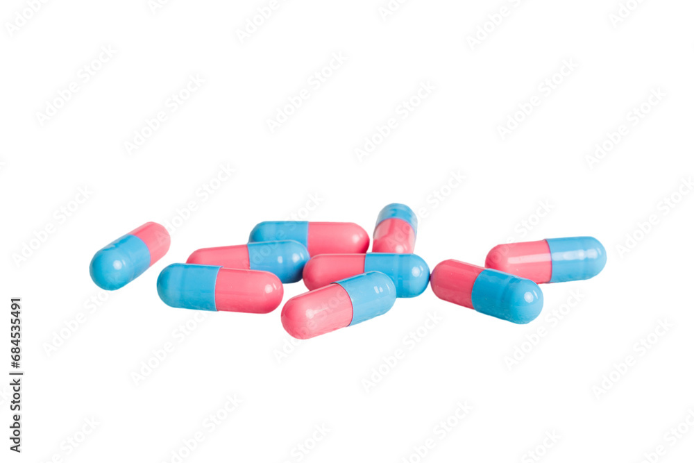 Heap of pink and blue pills on colored background. Tablets scattered on a table. Pile of red soft gelatin capsule. Vitamins and dietary supplements concept