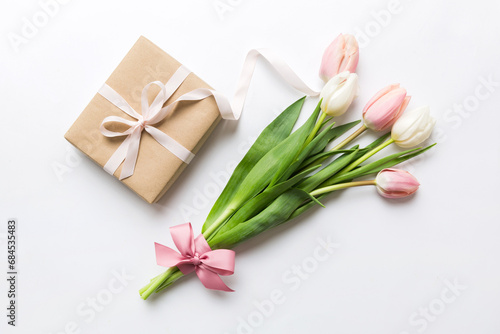 Pink tulips flowers and gift or present box on colored table background. Mothers Day, Birthday, Womens Day, celebration concept. Space for text top view © sosiukin
