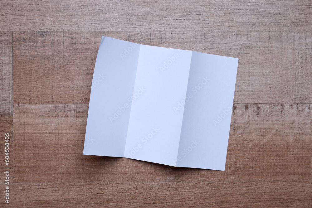 Blank white paper flyer for mock up on wooden background Blank white paper flyer for mock up on wooden background