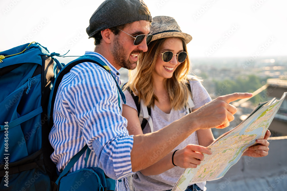 Happy couple on vacation sightseeing city with map. People travel fun honeymoon concept. - obrazy, fototapety, plakaty 