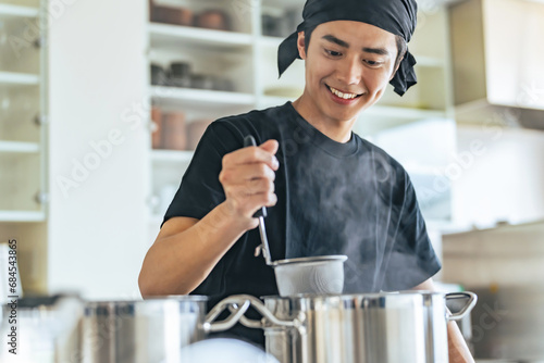 厨房で麺を茹でる飲食店店員 photo