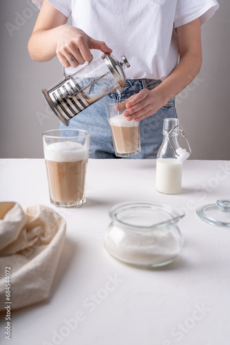 Making a latte. The process of preparing a coffee drink. Women's hands prepare a drink.