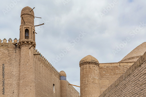 Narrow street between high walls with towers in the classic Central Asian style. On the left is the Khan's palace, on the right is the bazaar. Khiva (Xiva), Uzbekistan photo