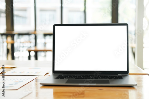 Blank screen laptop computer mockup on table in  modern office.
