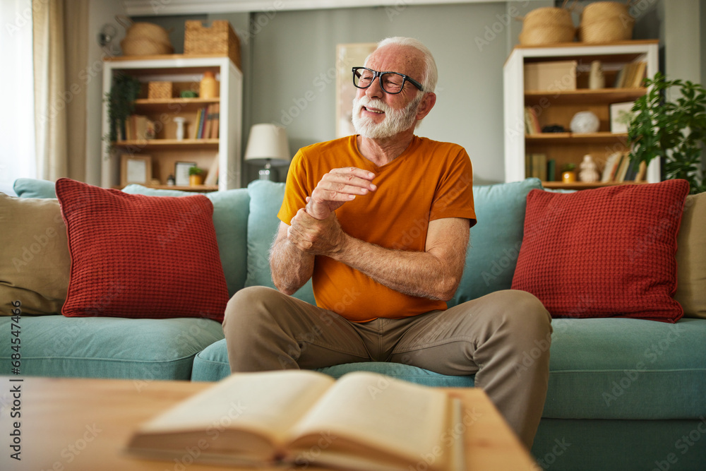 Elderly man suffering from his wrist joint pain at home Elderly man suffering from his wrist joint pain at home
