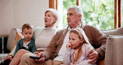 Watching tv or streaming with grandparents and children on a sofa in the living room of a home during a visit. Relax, subscription or entertainment with senior people looking after their grandkids photo
