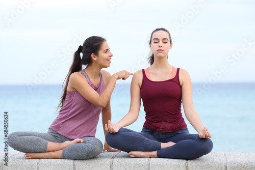 Woman doing yoga ignoring her friend