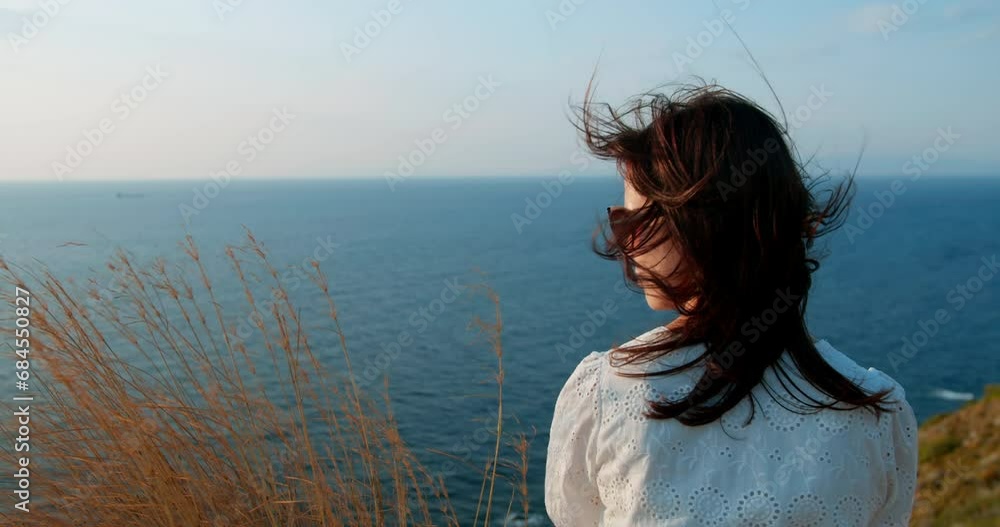 Woman admires beautiful sea view at sunset. Female enjoying summer vacation Woman admires beautiful sea view at sunset. Female enjoying summer vacation