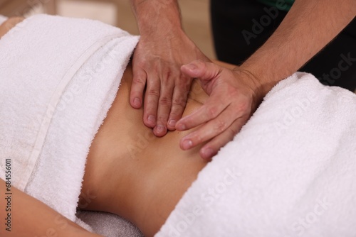 Woman receiving professional belly massage indoors, closeup