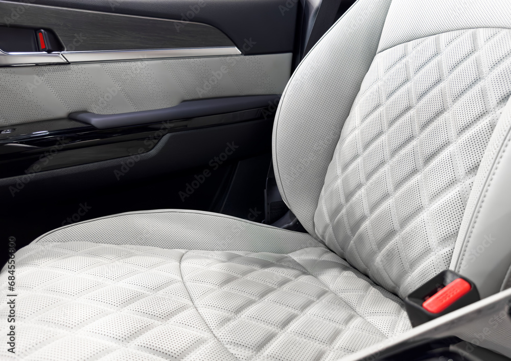 Obraz premium Car white leather interior. Part of white leather car seat details with white stitching. Interior of prestige car. Comfortable perforated leather seats. Perforated leather.