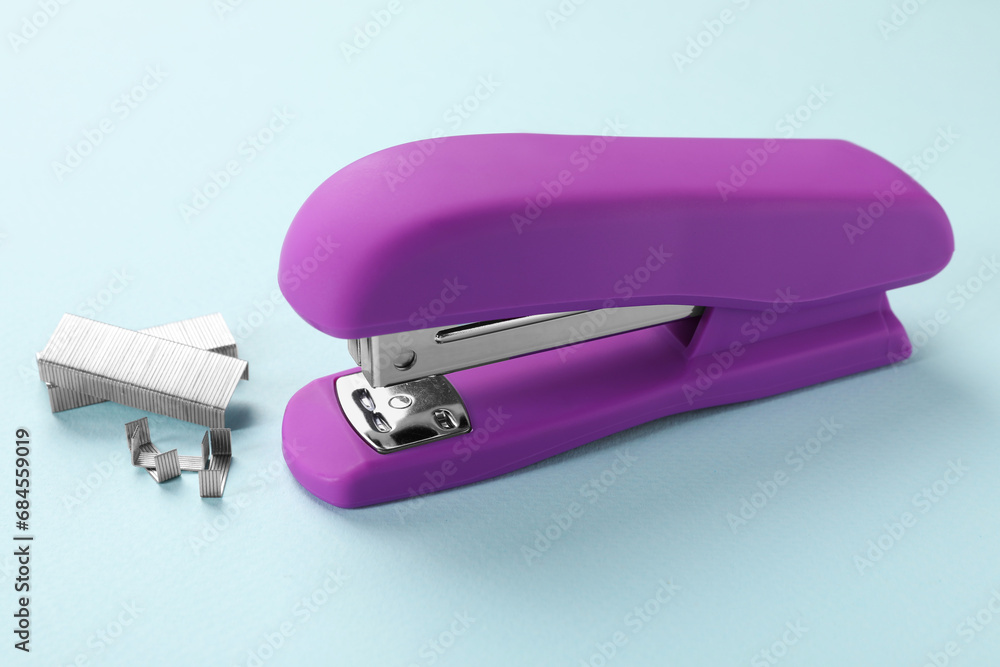 Bright stapler with staples on light blue background Bright stapler with staples on light blue background