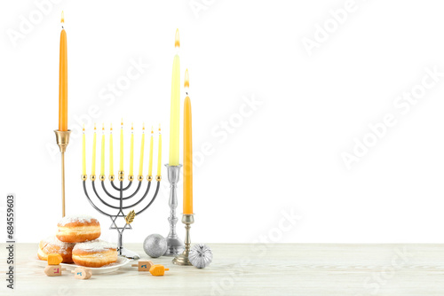 Hanukkah celebration. Composition with menorah  dreidels and gift boxes on wooden table against white background