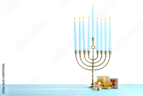 Hanukkah celebration. Menorah, dreidels and gift boxes on light blue wooden table against white background