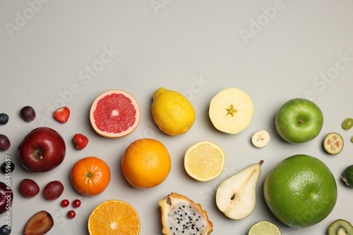 Different ripe fruits and berries on light gray background, flat lay. Space for text photo